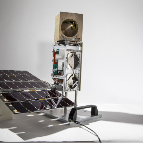 A photo of a small satellite in a studio
