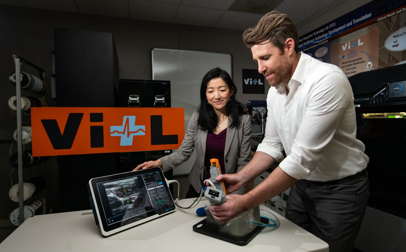 Research team members Matt Johnson and Laura Brattain test their new medical device on an artificial model of human tissue and blood vessels.