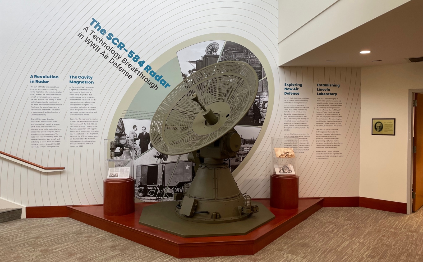 A photograph of the SCR-584 radar at Lincoln Laboratory in front of a wall of text about its development and use in World War II.