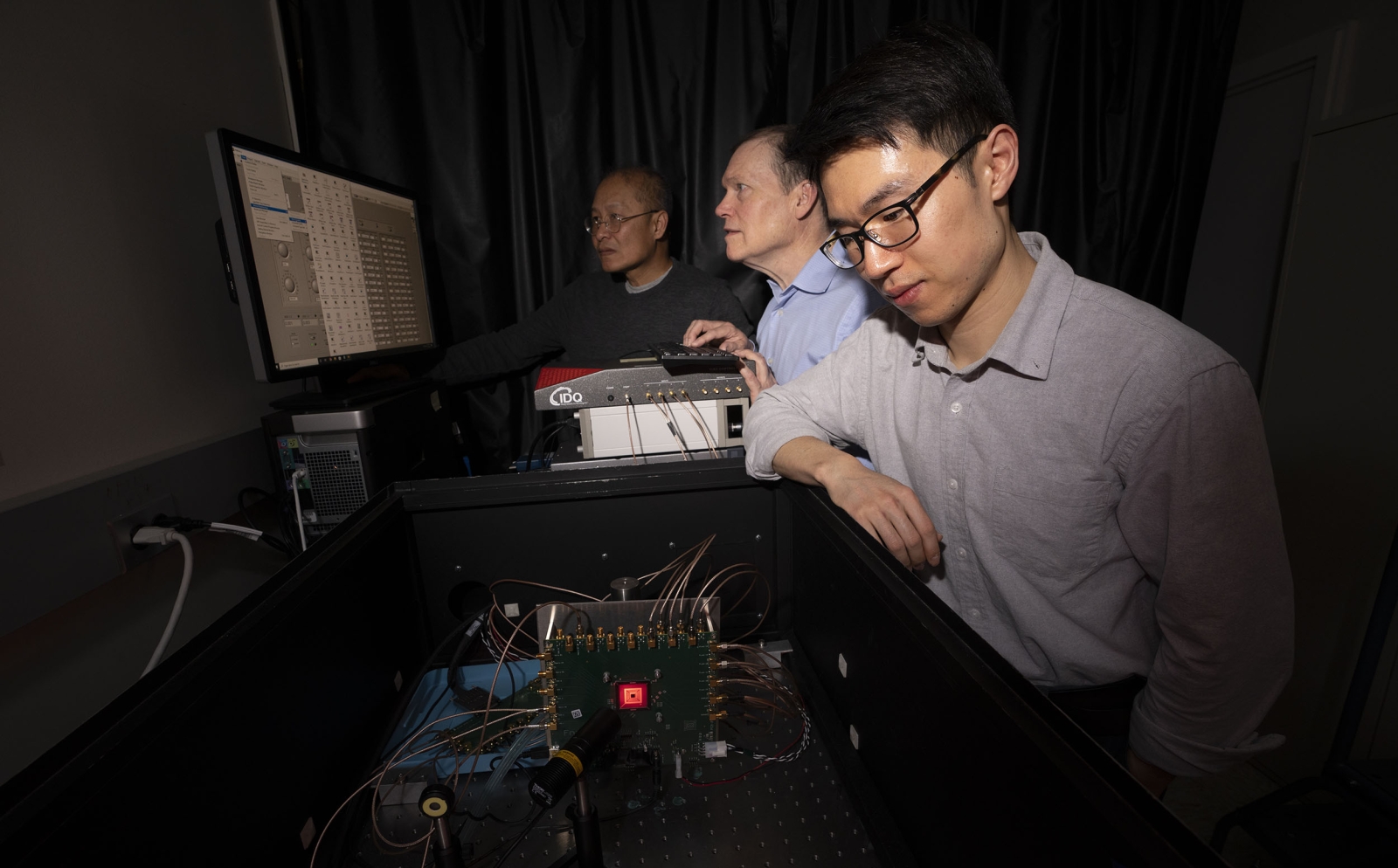 From left to right, Niyom Lue, Jonathan Richardson, and Tom Cheng test the detector in the laboratory.