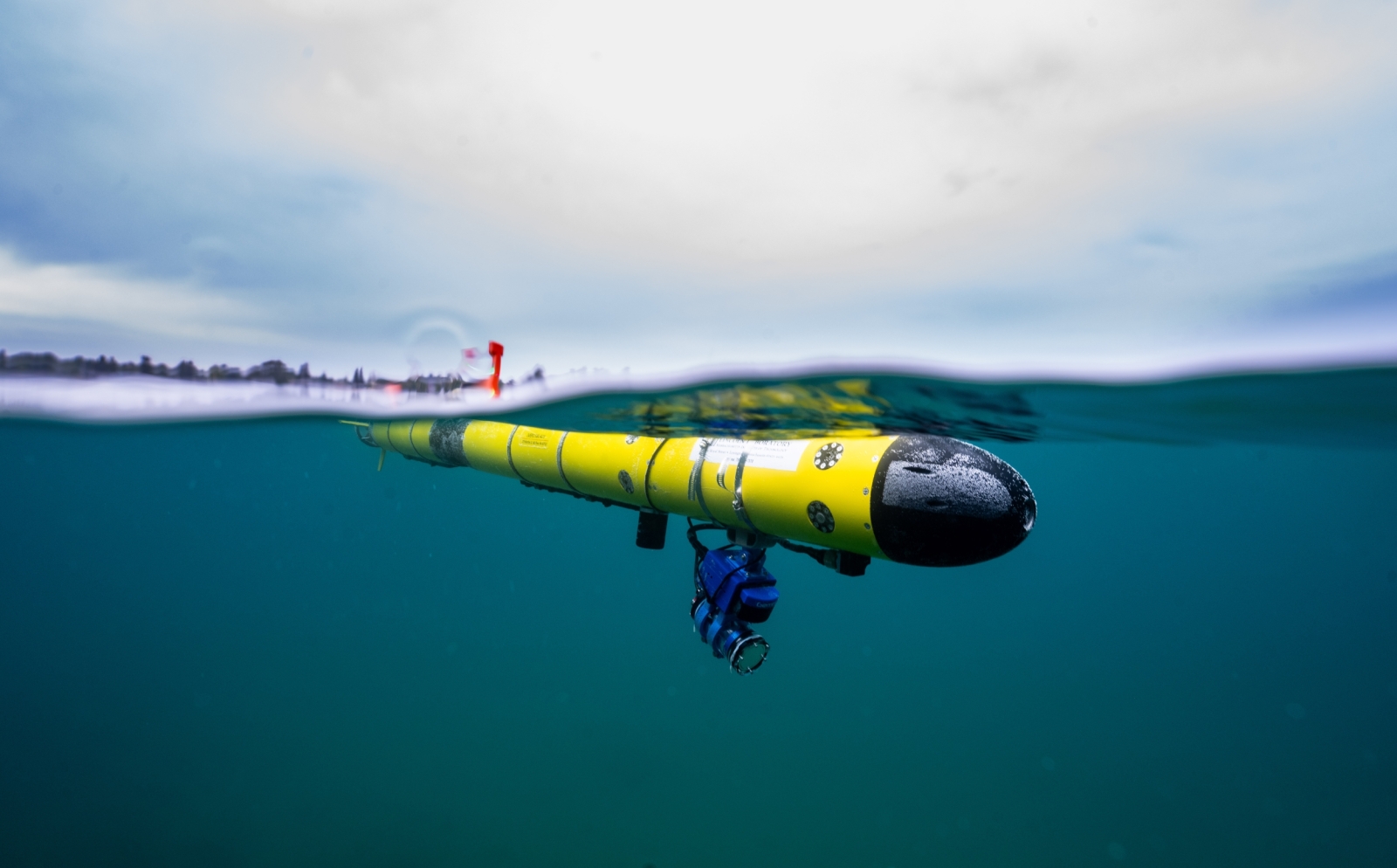 A photo of an underwater robot just under the surface of water. 