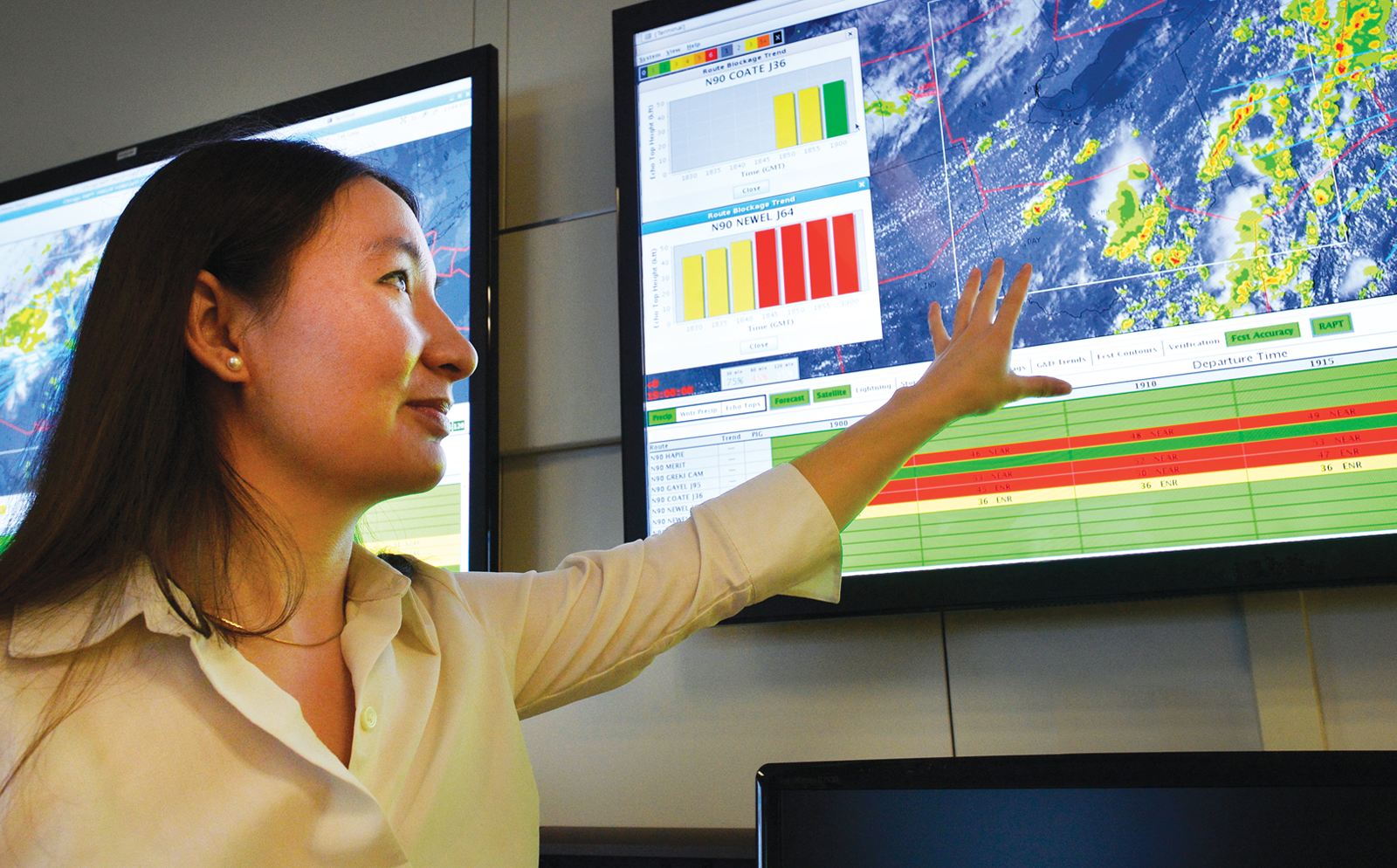 woman points to an air traffic control display screen
