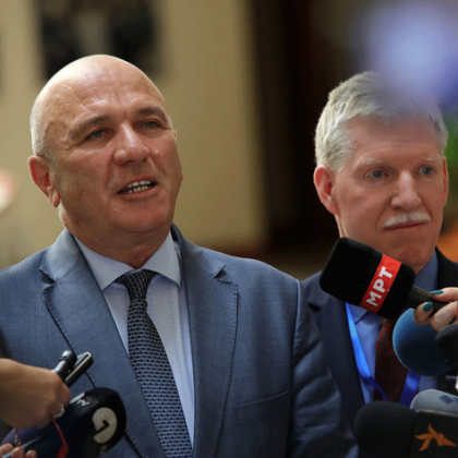 Photo of two men talking into microphones at a press conference