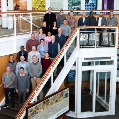 A group of 24 people representing Lincoln Laboratory and students and staff of the Air Command and Staff college pose for a group photo. 