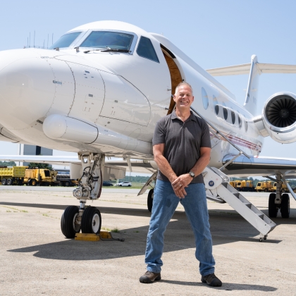 An individual stands in front of an aircraft.