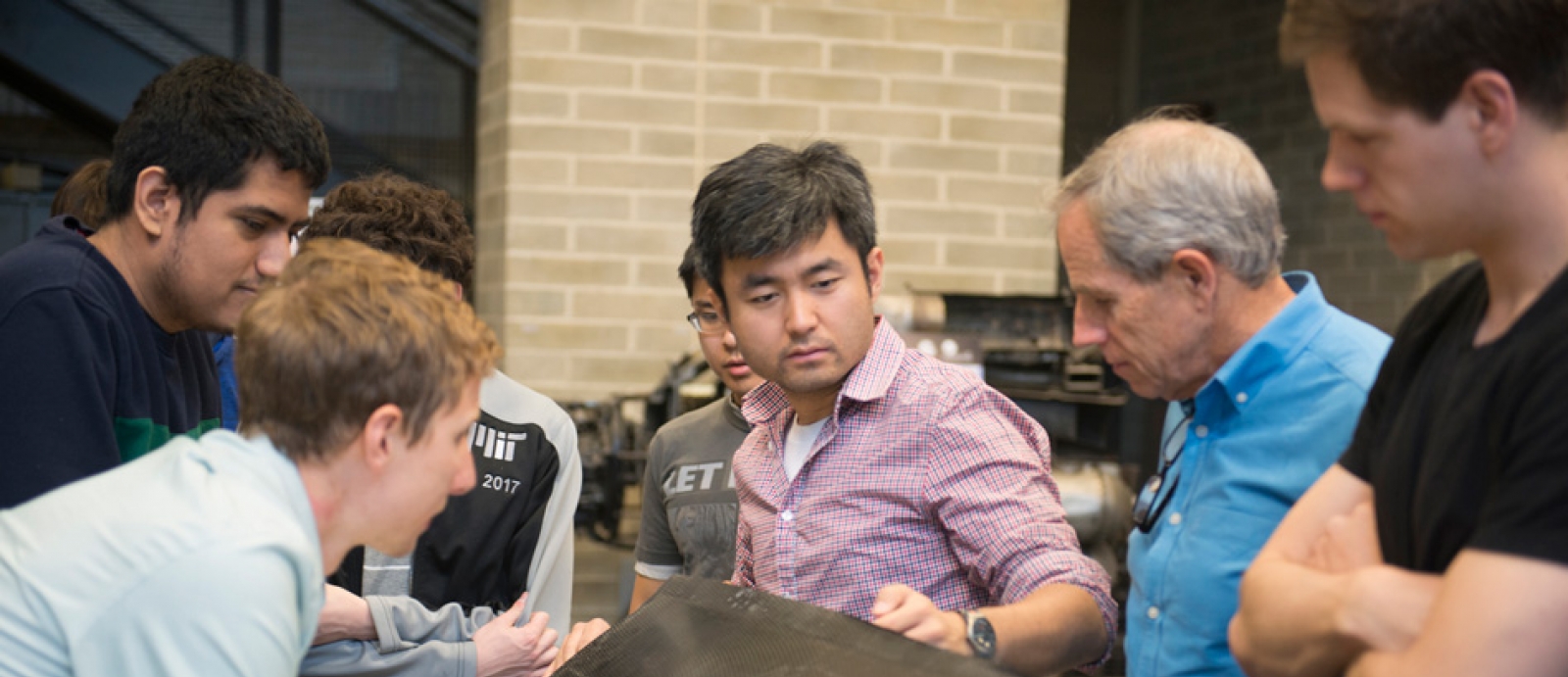 JHO team examines one of the aircraft’s carbon fiber wings, constructed by the student team in AeroAstro’s Building 33 Neumann Hangar. Photo: MIT News