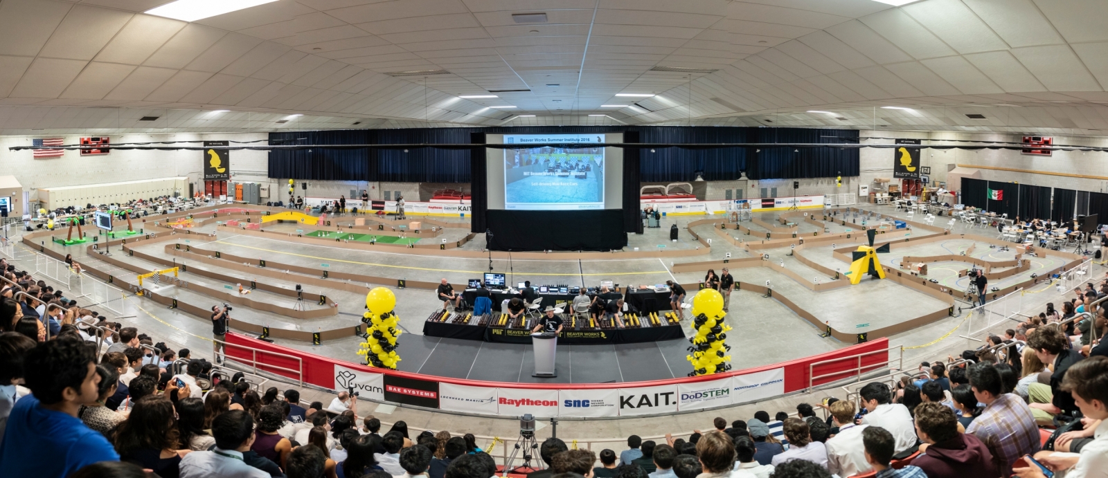 Robert Shin speaks to attendees of this year's Beaver Works Summer Institute final event with the RACECAR obstacle course in the background. Photo: Glen Cooper