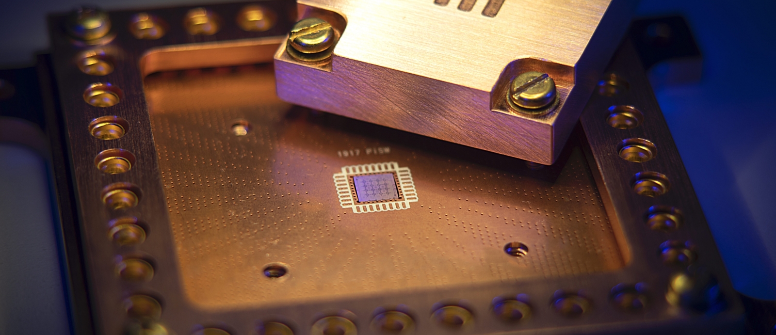 A photo of a quantum chip with MIT etched into metal. 