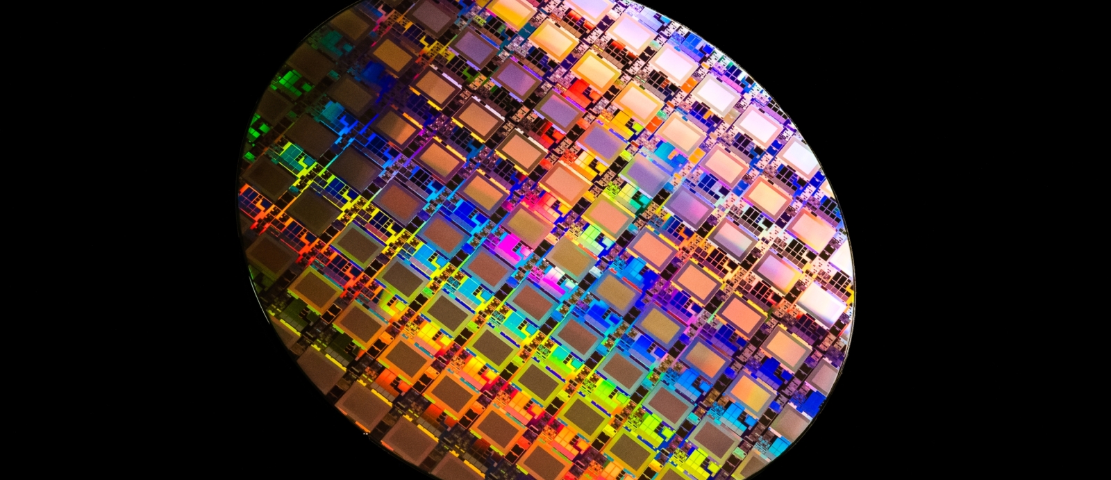 A photo of a multicolored wafer containing integrated circuits. 