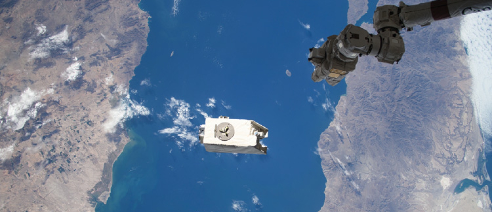 A payload shown above the Gulf of California, just after it was jettisoned by a robotic arm from the International Space Station into orbit.
