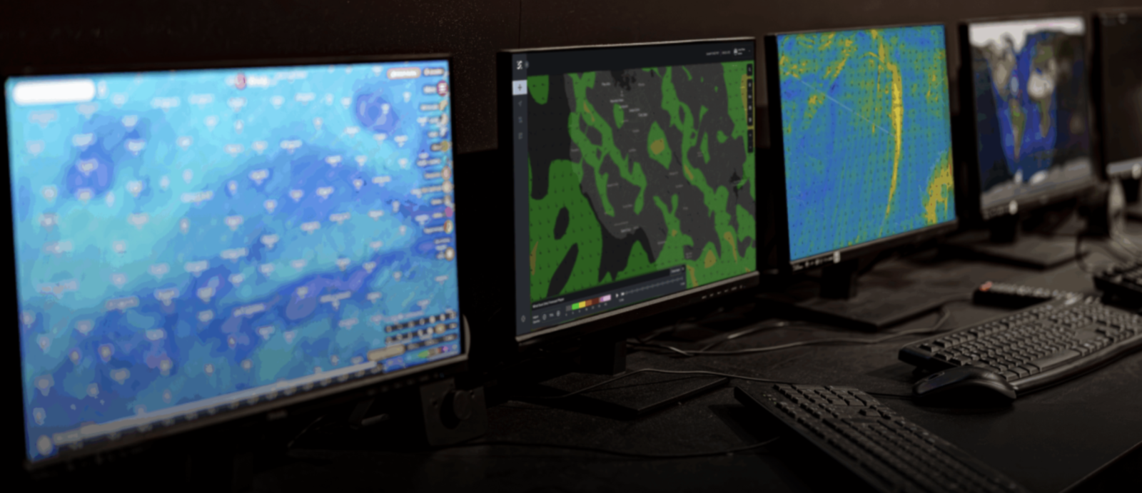 Four monitors displaying weather and air radar returns