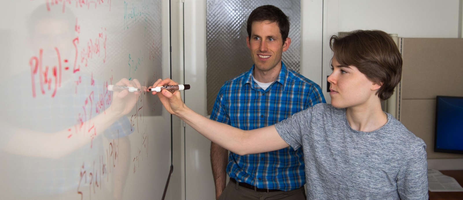 As mentor Henry Romero looks on, UROP student Gabriela Studt does calculations to compare soft-decision decoding algorithms for Reed-Solomon error-correcting codes.