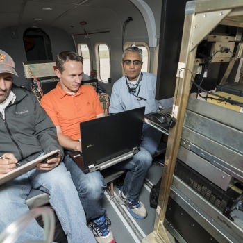 Alex Vasile works on processing initial data, while Brandon Call, from the business 3DEO which specializes in lidar technology,assists with integrating the system. Rajan Gurjar (right), is putting together plans for a local flight test. Photo: Glen Cooper