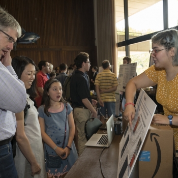 Isabel MacGinnitie, right, a student in the Build a Cubesat course, explains her project to visitors at the Stratton Student Center. Photo: Glen Cooper