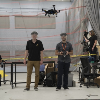 Autonomous Air Vehicle Racing course instructor Ross Allen, left, and student Christopher Evagora, right, look on as an autonomous vehicle completes its flight around the track. Photo: Glen Cooper