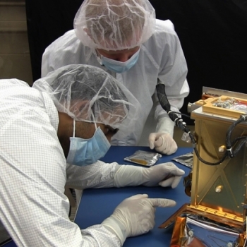 MIT graduate students Pronoy Biswas (left) and Mark Chodas (right) prepare the REXIS instrument for flight. Photo: William Litant/MIT