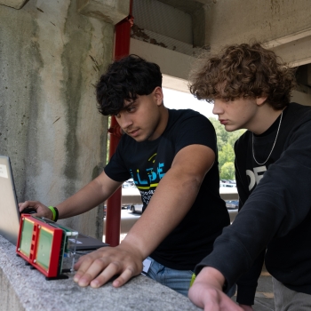 Two LLRISE students look at a laptop outside in the Laboratory's parking garage to see the results of a radar exercise. 