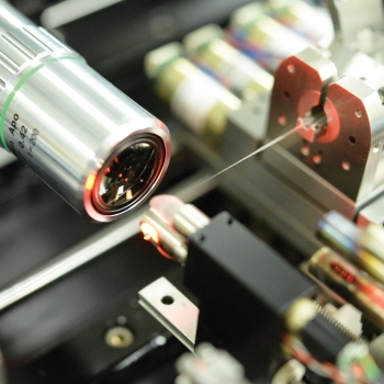Photo of the photonic lantern, which is fabricated on a high-precision mechanical system. The tip of the photonic lantern is inspected with a microscope objective prior to the lantern’s being spliced to a fiber.