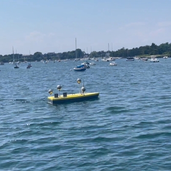 Photo of a 12-foot, all-electric prototype ASV with the sonar array mounted underneath .