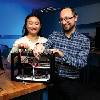Andrea Lin and Samuel Jero adjust a ground-to-space test bed running Magnetite. The test bed demonstrates encrypted end-to-end communication between a ground station and a notional satellite using NASA’s core flight software.