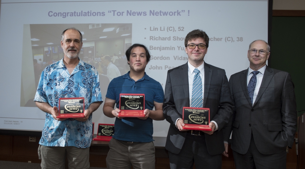 Members of the winning team, Tor News Network, accept trophies presented by Bob Bond, Chief Technology Officer.