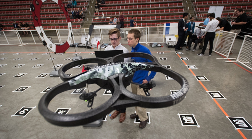 Students from the unmanned aerial vehicle course race their quadcopter through the obstacle course.