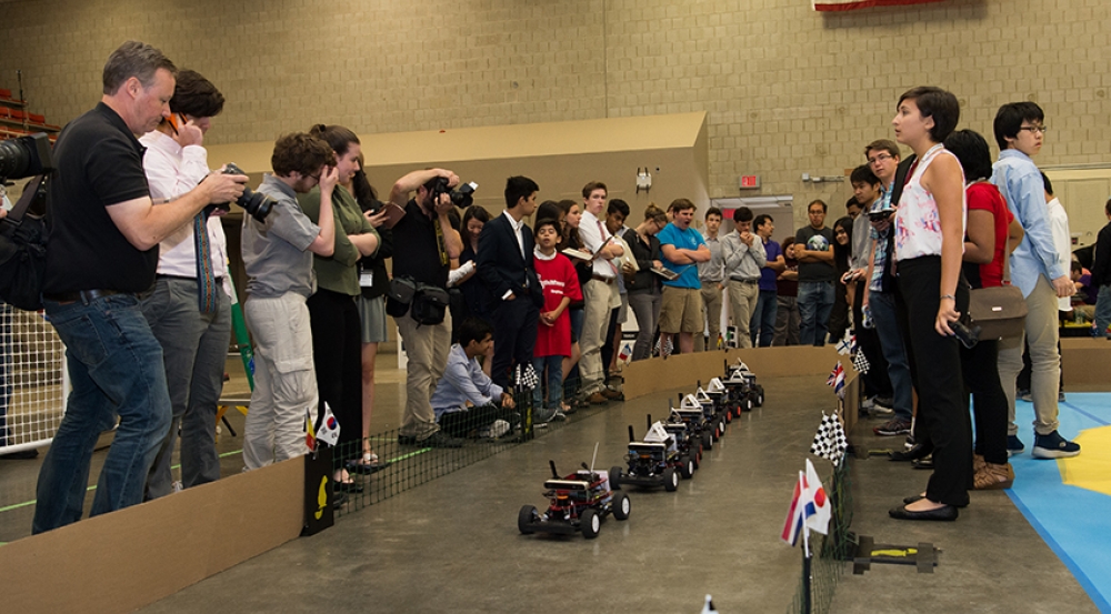 Students and spectators at starting line wait for the opening of the autonomous racecar Grand Prix.