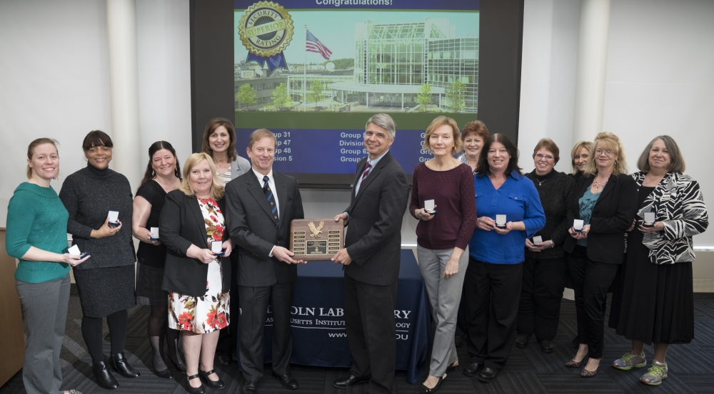 Holding the 12th consecutive Superior Security rating plaque are Shawn Daley, head of Security Services, left, and Eric Evans, Laboratory director. Joining them are representatives from the groups and divisions audited for the 2017 security review.