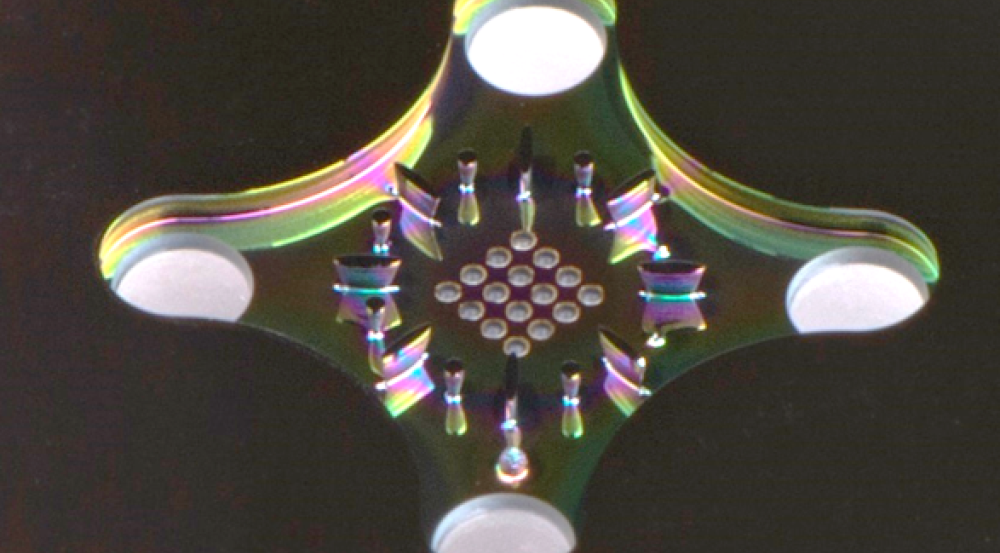 A zoomed in photo of the cooling technology - a small piece of metal with tiny holes drilled in the middle of it.