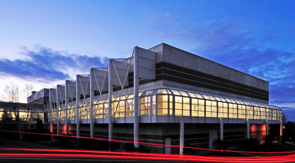 an exterior shot of the Microelectronics Laboratory building. It is dusk, and a long-exposure technique creates a long red streak through the image.