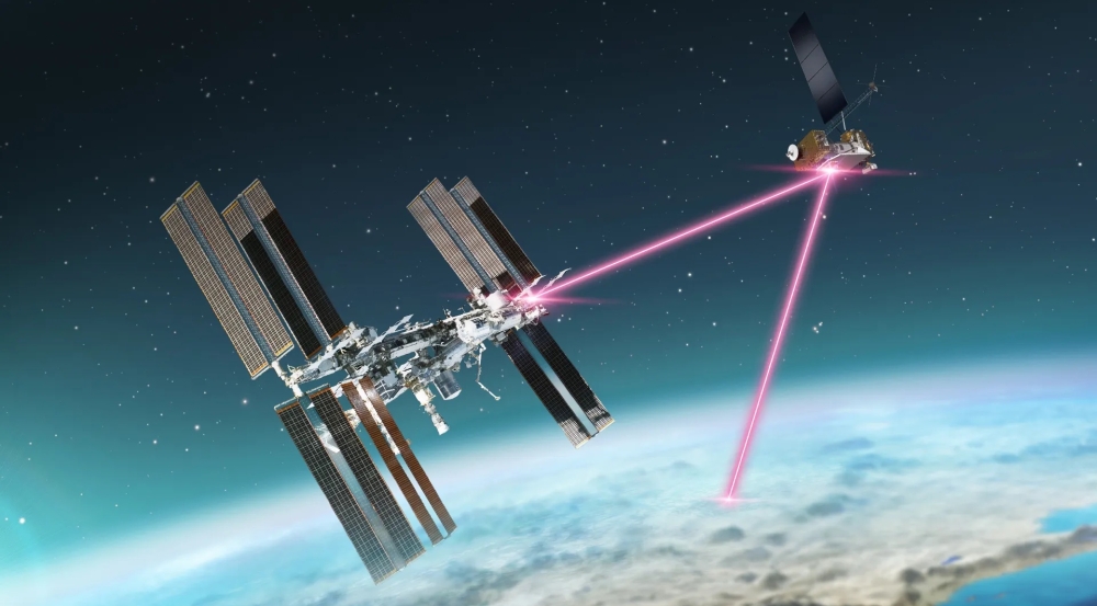 A schematic of a laser communications terminal onboard the International Space Station transmitting data over laser signals to a smaller satellite at a higher altitude; this satellite then relays the data to Earth.