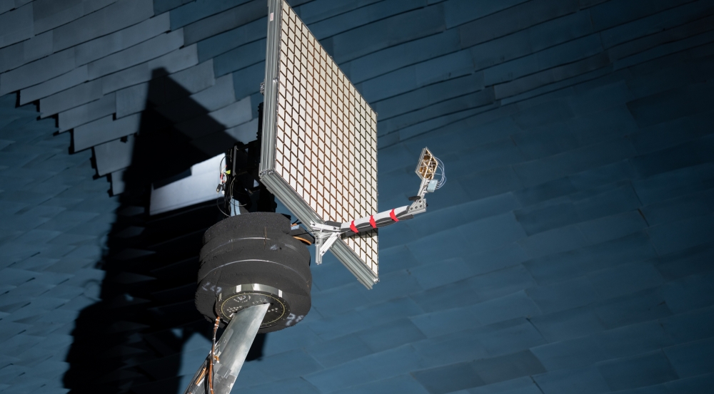 An antenna with 256 small elements is held up in an anechoic chamber. 
