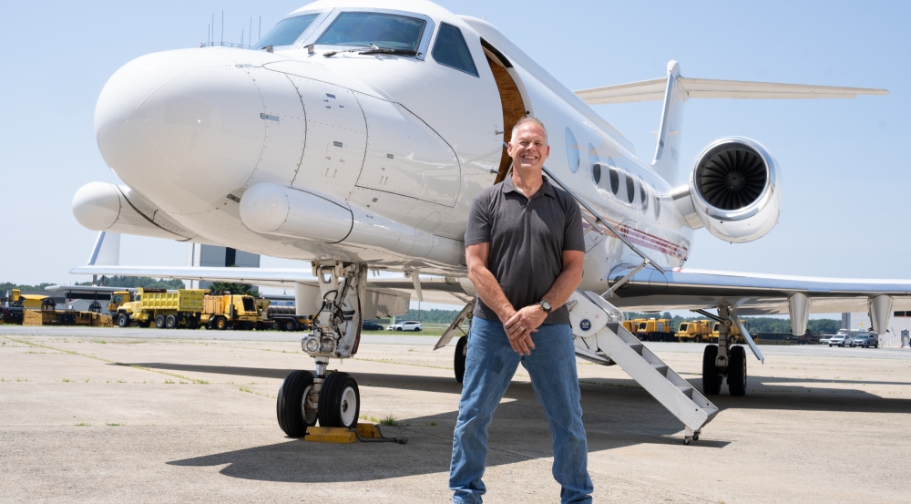 An individual stands in front of an aircraft.