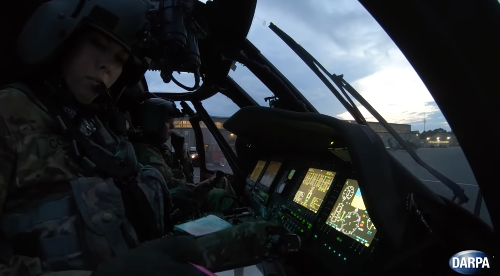 A photo of two military personnel in a helicopter.
