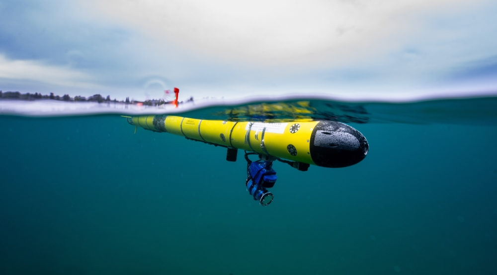 A photo of an underwater robot just under the surface of water. 