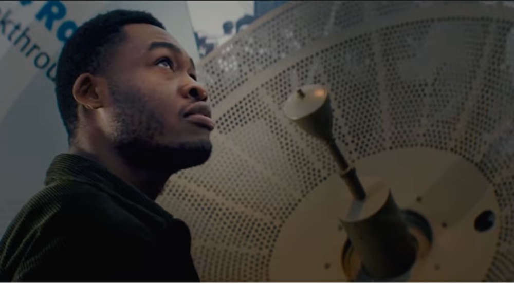 A man looks up with a radar featured in the background.