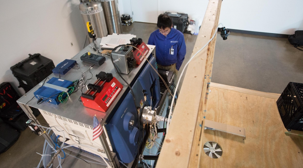 Researchers conducted vapor measurements in situ with canines. The canines walked up onto the wooden platform to smell a training object while the mass spectrometer validated the presence of trace explosive vapors on the object.