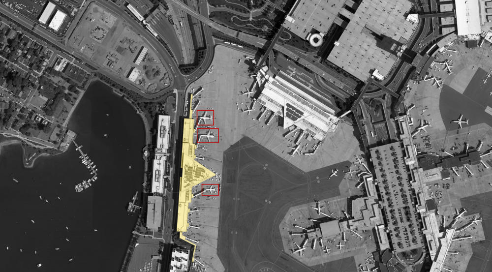 A goal of the program is to develop a system that can identify spatial relationships between objects in a scene, such as counting how many planes are parked at the terminal on the left.