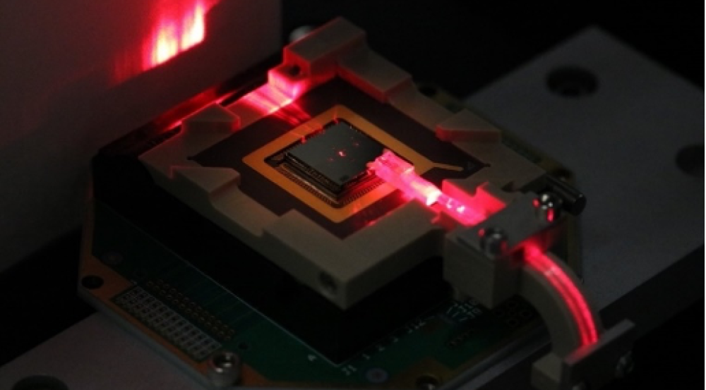a small electronic chip is illuminated with red laser light. 