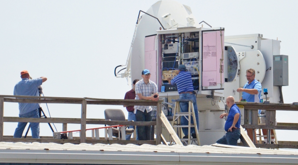 Six people work on radars at a naval air station.
