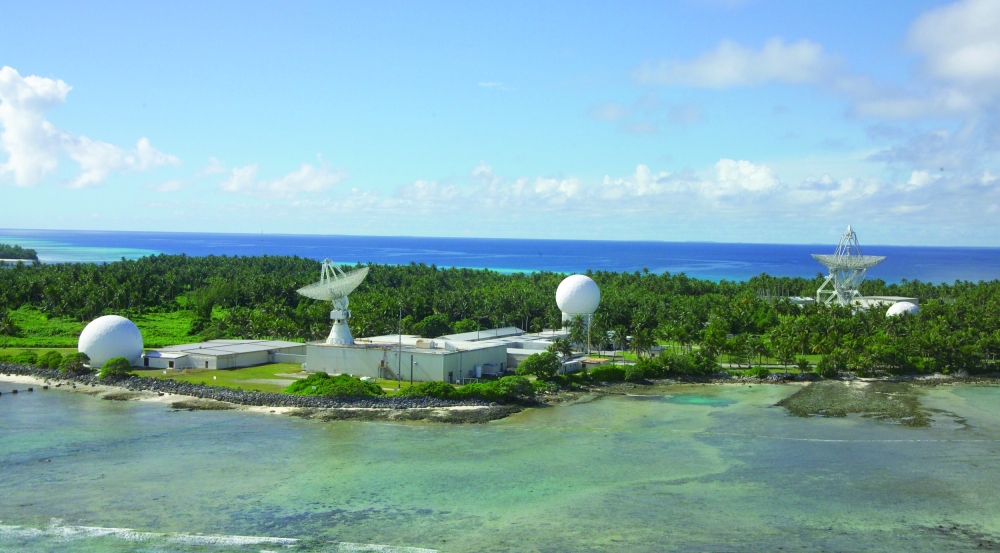 A photograph of an island with four radars.