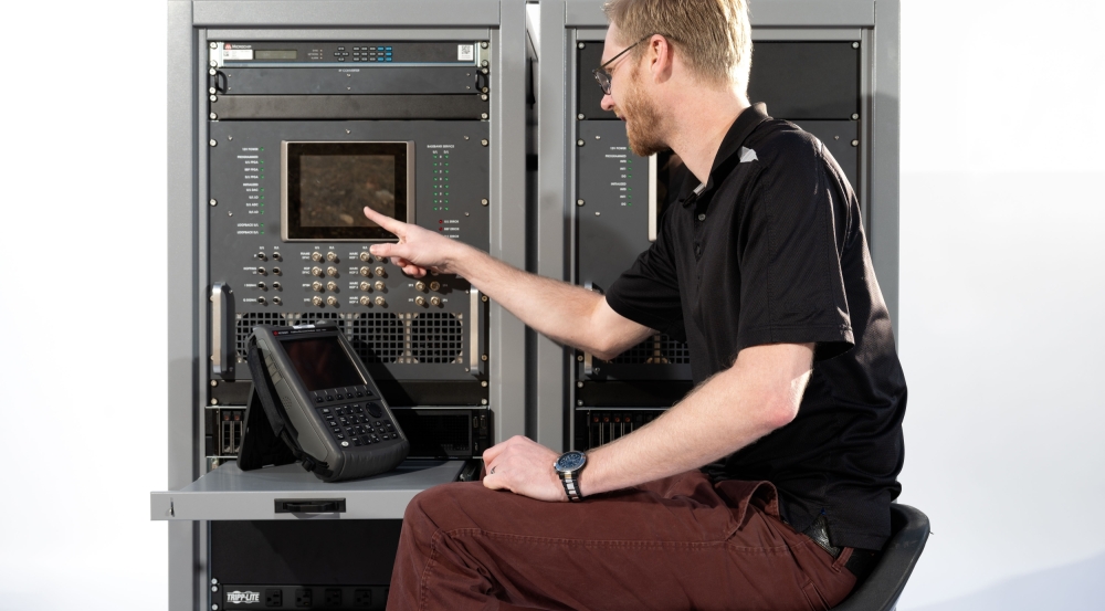An individual sitting in front of a test terminal presses a button.