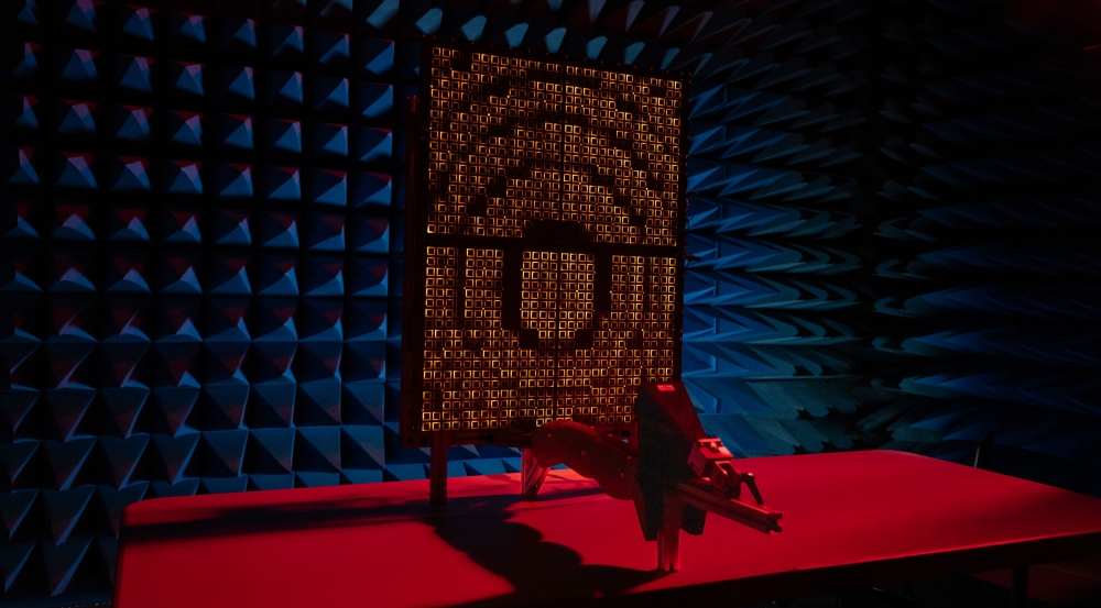 A prototype reflectarray faces a feed horn in an anechoic chamber.