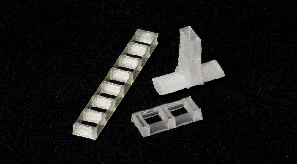 Shown above, devices printed from copolymer inks include an eight-block dielectric bandpass filter (left), a three-block dielectric bandpass filter (bottom), and a dielectric lens for a waveguide antenna.