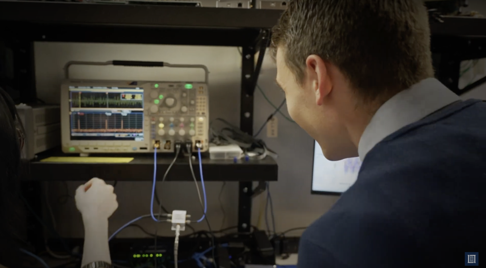 a photo of an intern looking at a piece of equipment showing signals