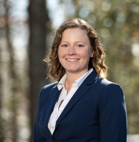 A portrait photograph of Kat Riesing outdoors in wooded environment.