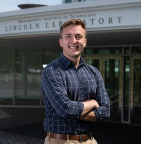 A portrait photograph of Joseph Rottner outside the front entrance of MIT Lincoln Laboratory.