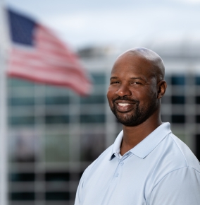 Henrie Young poses for a photo outside, with the U.S. flag in the background.