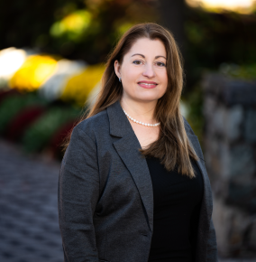 Photo of Emilia Klein outdoors with greenery behind.