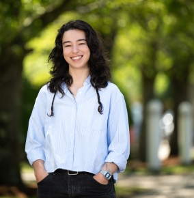 Mirit Rutishauser stands outside and smiles with green trees in the background.
